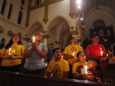 Worshipers participate in a "United To Heal Prayer Vigil" at Cathedral Guadalupe in Dallas on Friday, in honor of the police officers who were slain on Thursday. 